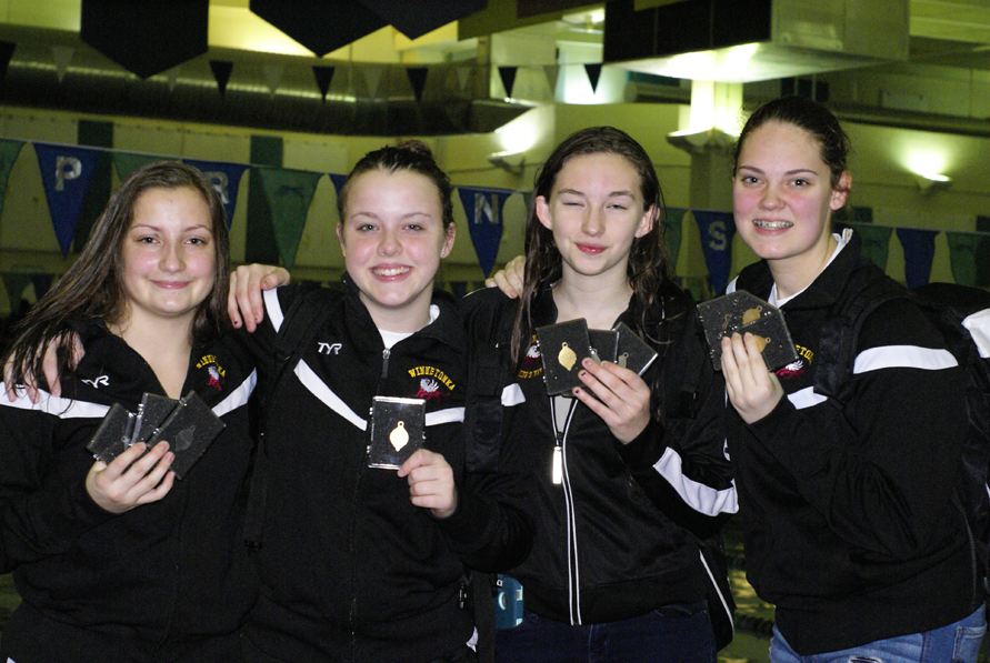 Junior Suzanna Zimmerman, (left) freshmen Emily Reed, Kathryn Bullock and Anna Braman posing with their medals after the JV conference swim meet on Jan. 28.