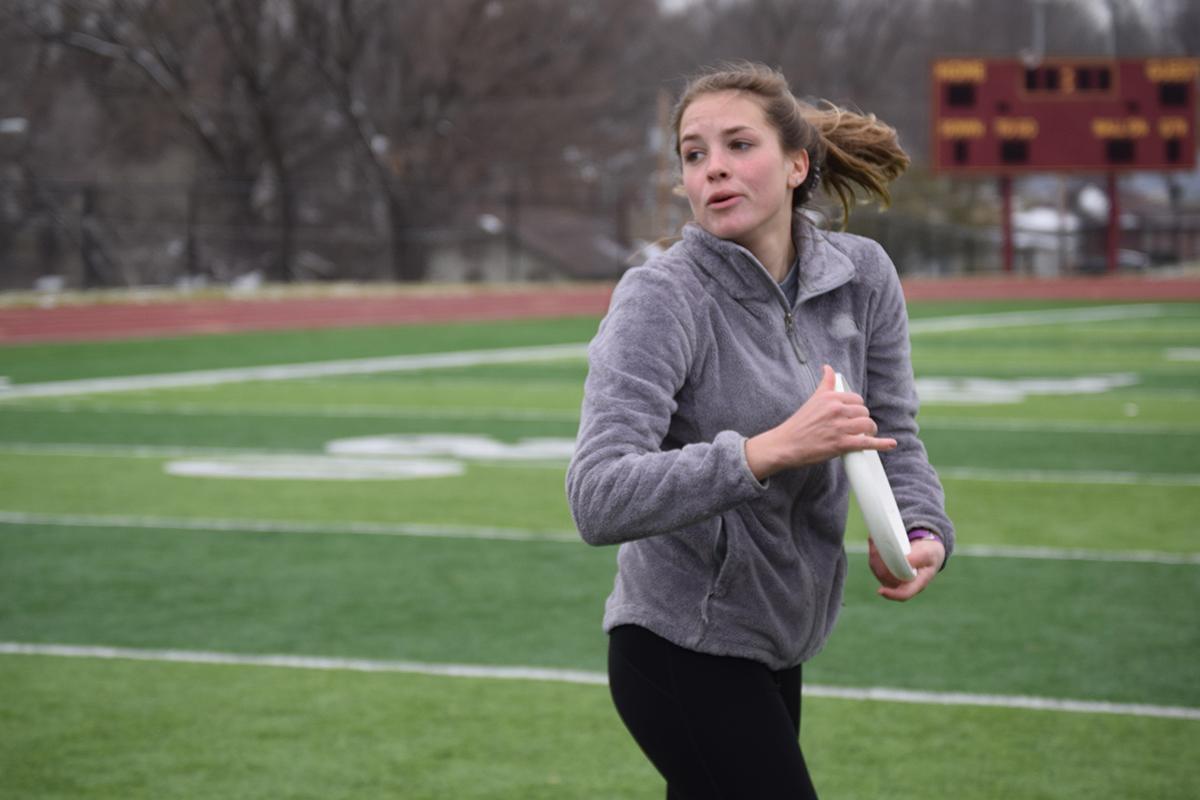 Senior Cayla Adamson spins around while holding the frisbee in order to throw it to another teammate.