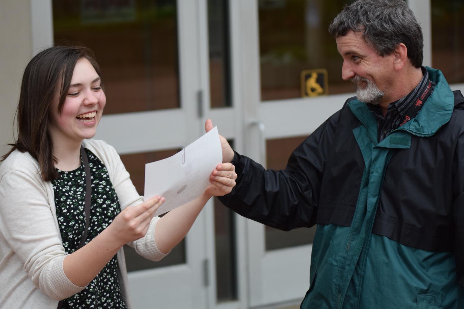 Sophomore+Jessica+Glaszczak+laughs+excitedly+as+she+receives+her+State+1+certificate+from+orchestra+director+Henry+Bullock.+