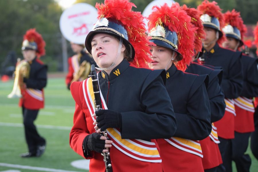 Junior Bella Middaugh marches with the PRIDE band while playing clarinet at the Sept. 29 homecoming football game before the first quarter. Middaugh was selected as the 11th chair clarinet for the Kansas City Metro All-District Band.