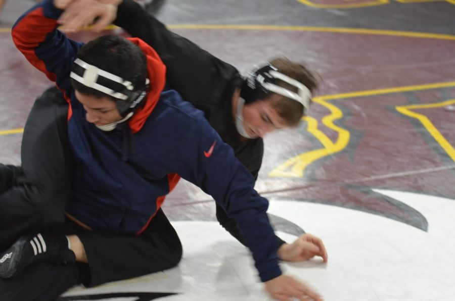 Junior John Murray wrestles with his opponent at practice on Jan. 29. Murray won three of five matches at conference on Feb. 10.