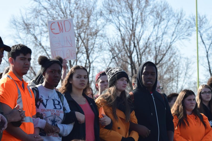 Senior Kennedi Walker and juniors Rosie Rodriguez and Makayla Cambiano link arms during the protest against gun violence. 
