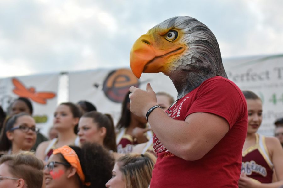Senior Jackson Mattingly wears a plastic griffins mask as he stands on the senior wall at the Aug. 18 varsity football game against Park Hill South at the North Kansas City District Stadium. 