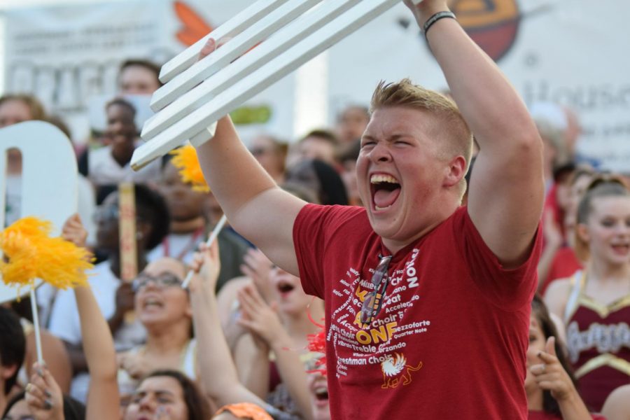 Senior Jackson Mattingly screams while he swings the fence part of the D-fence sign in the air at the Aug. 18 football game against Park Hill South.