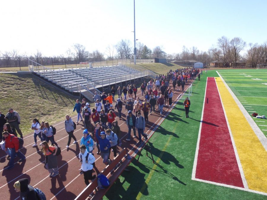 A large group of seniors and underclassmen walk together during the March 14 school walkout against gun violence.